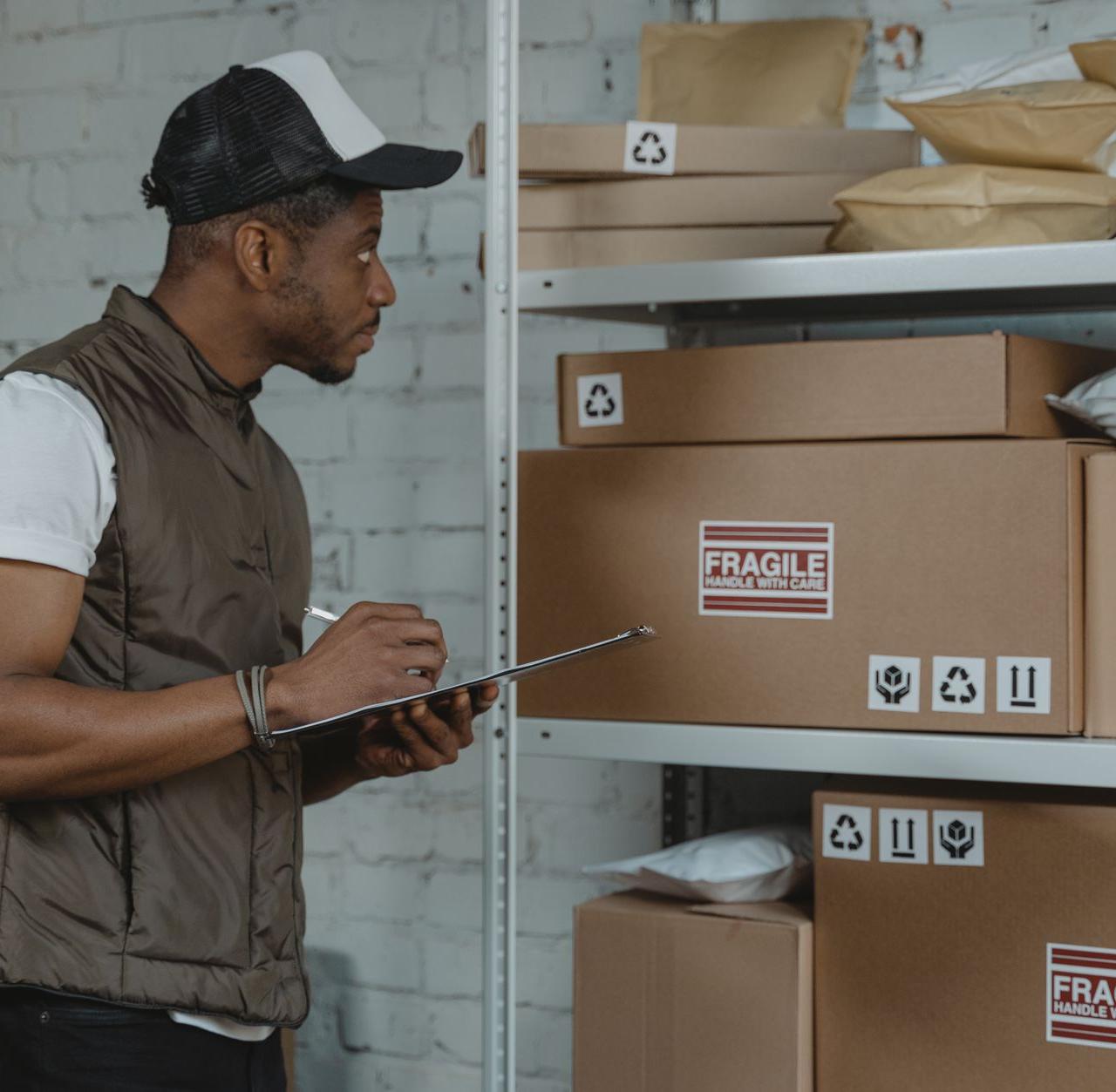 Courier checking packages in a warehouse, ensuring fragile handling