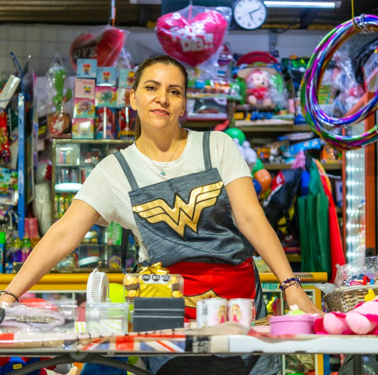 Woman proudly standing at her colorful market stall in Ciudad de México.
