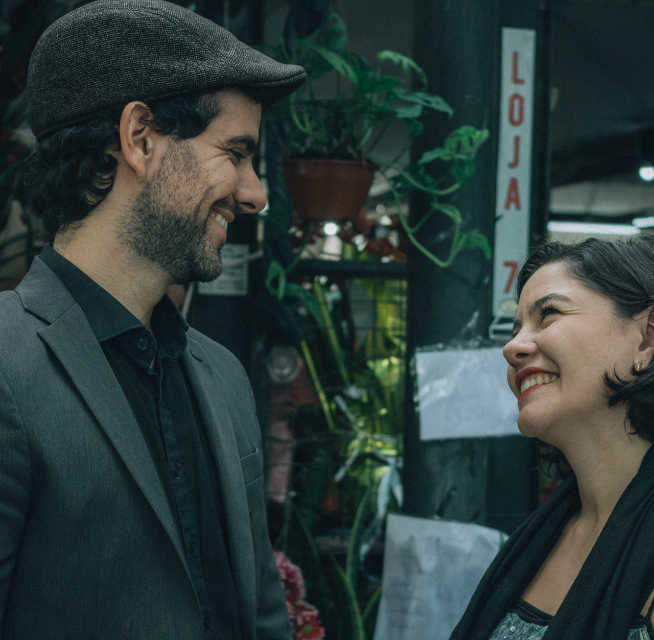 A couple sharing a joyful moment at a vibrant market outdoor setting.