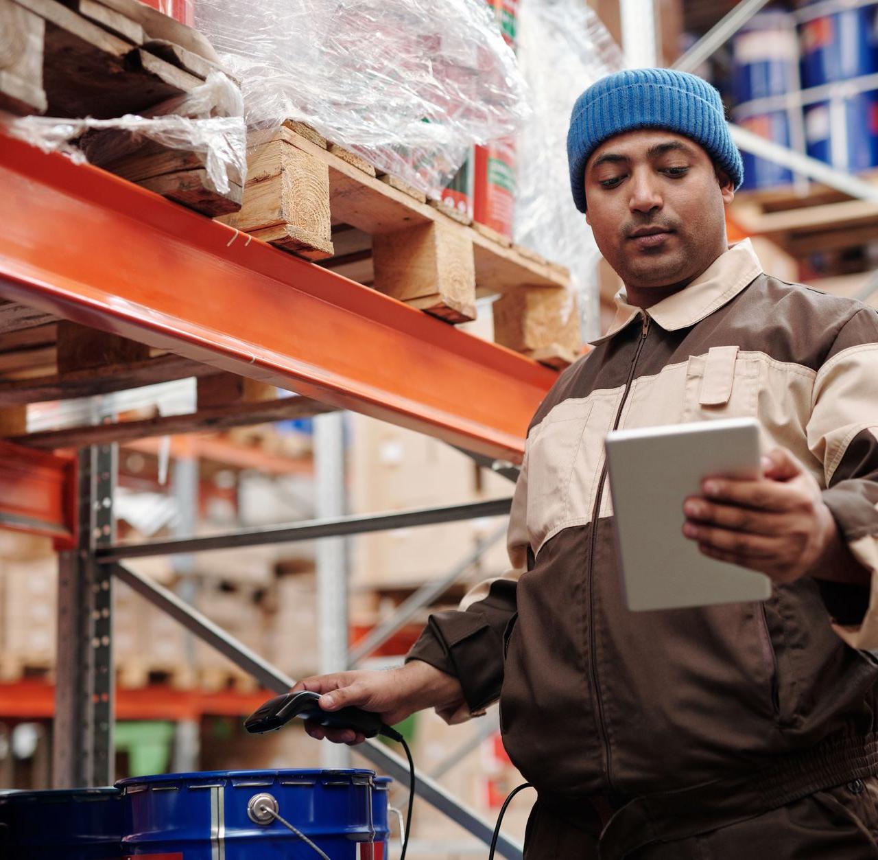 A warehouse employee scans items using a tablet, ensuring inventory accuracy.