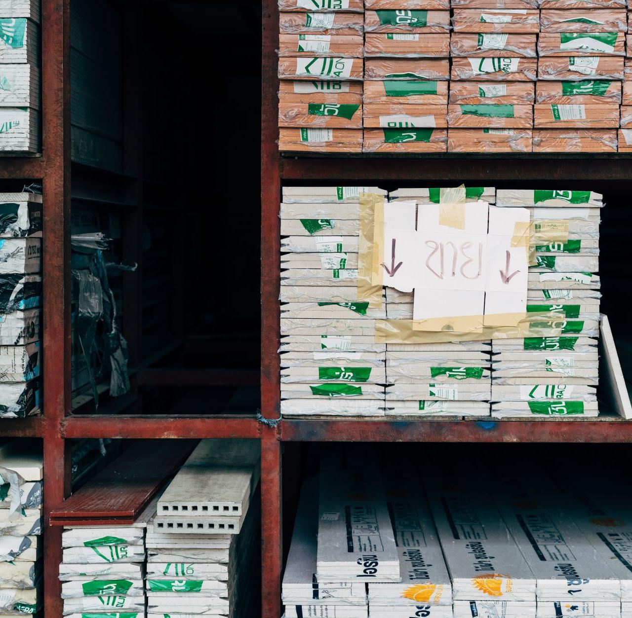 Image of a warehouse showcasing organized stacks of building materials on shelves.