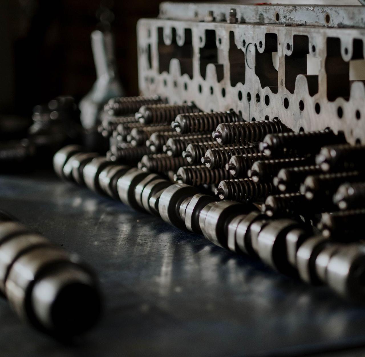Detailed close-up of engine components including camshafts and springs on a workbench.