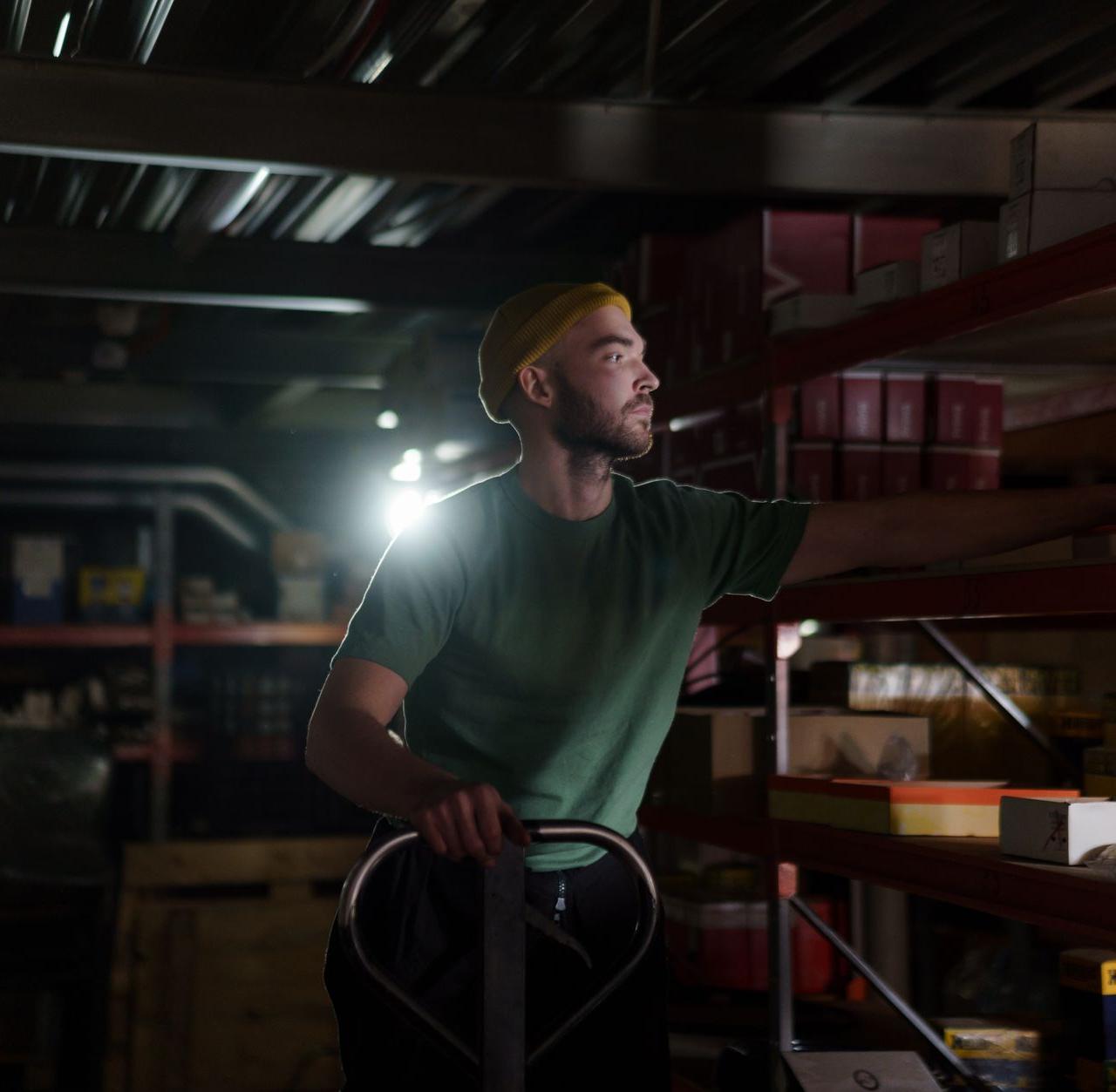 A dedicated worker organizing inventory on warehouse shelves with focused concentration.