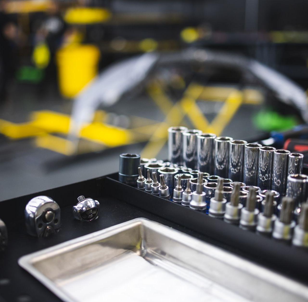 Assorted tools and ratchets arranged in an auto workshop setting.