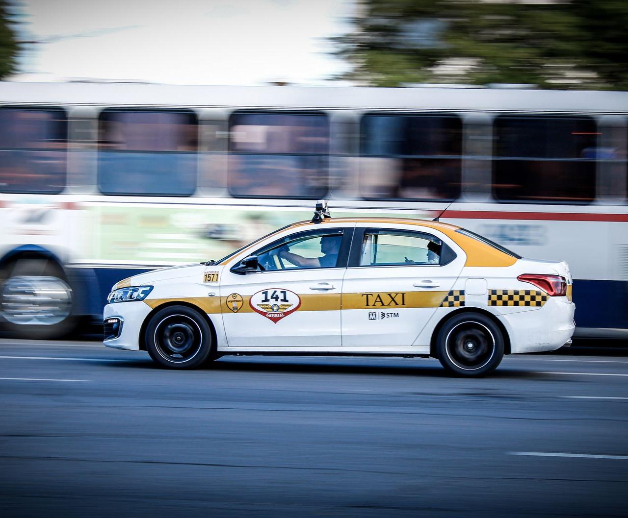 A yellow and white taxi speeding through Montevideo city streets, captured with motion blur effect.