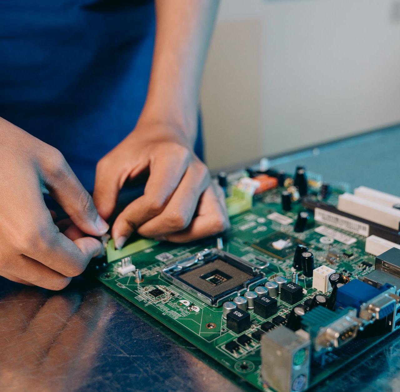 Hands-on assembly of a computer motherboard with precision tools.