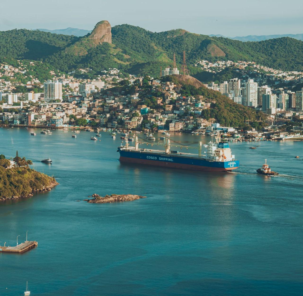 A stunning aerial view of Salvador harbor featuring a cargo ship and surrounding cityscape.